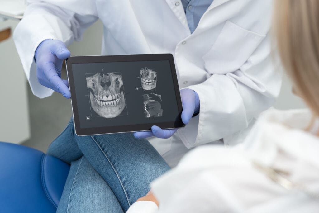 A patient is holding an x-ray of her dental implants.